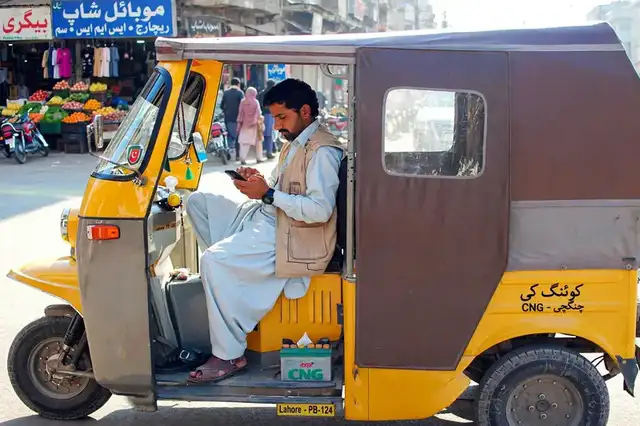 Qingqi driver typing an SMS on his phone